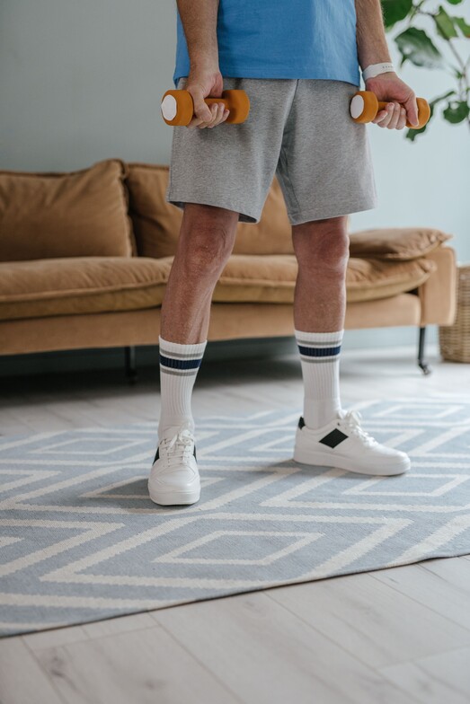 image of person holding light weight dumbbells